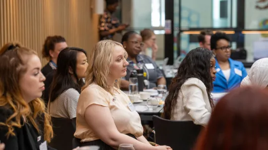 A group of people sitting down at tables during a workshop.