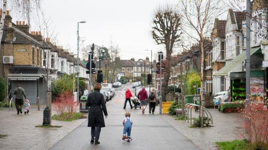 A parent and child walk down francis road in Leyton.