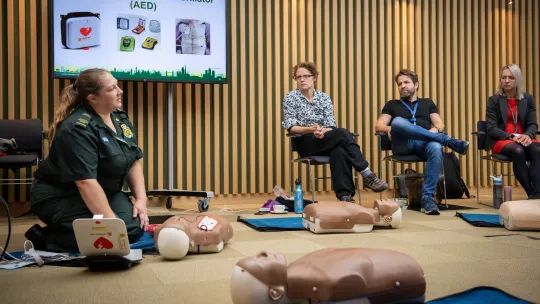 A paramedic demonstrating CPR to a classroom