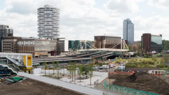 wide view of a train station city buildings behand and surrounding area
