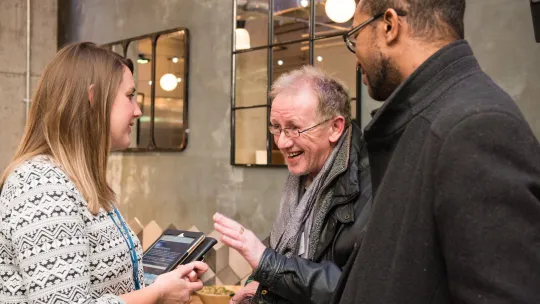 Three people talking at consultation event
