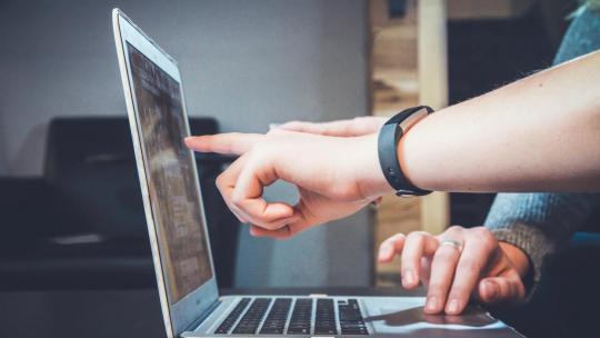 People pointing at laptop screen