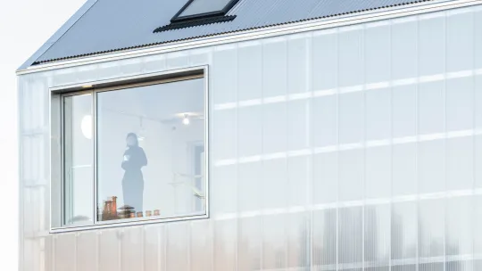 View of woman standing in top floor office window