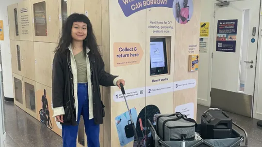 A person standing in front of the Library of Things kiosk