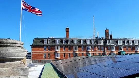 Rooftop with solar panels and a flag pole with a union jack flag
