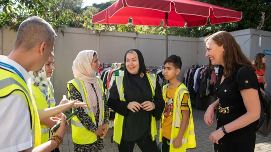 Photo showing volunteers in conversation with a family at Lewisham Donation Hub