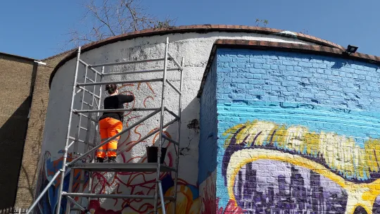 A mural in London being painted by a female artist 