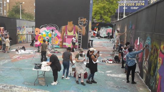 People gathered to paint murals, for where are the women project