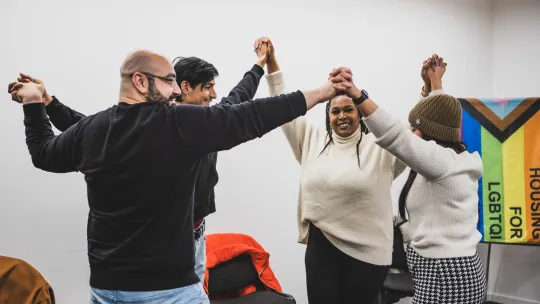 Micro Rainbow theatre lab participants hold hands to represent a caring community