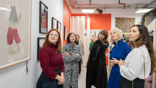 group of people standing and looking at artwork