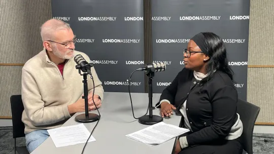 older man and young woman talking into microphones