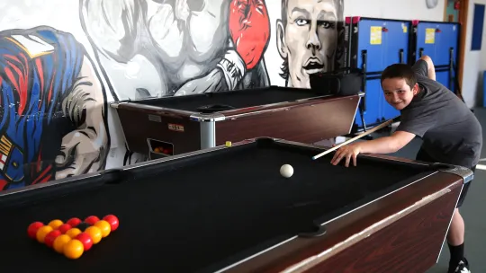 young person playing pool
