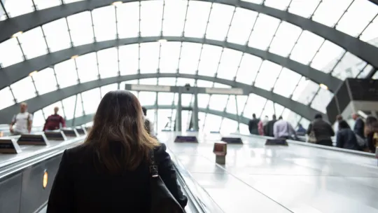 Woman travelling up escalator in Canary Wharf tube station