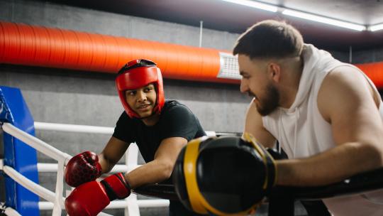 Young person and their mentor take a break during a summer holiday activity at a boxing club in London.