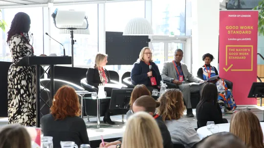 People on a stage on a panel with audience members