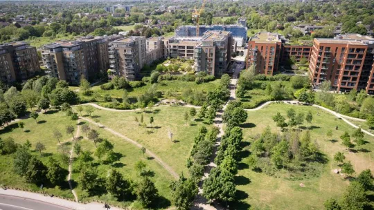 Housing development, green space in front and homes at the back