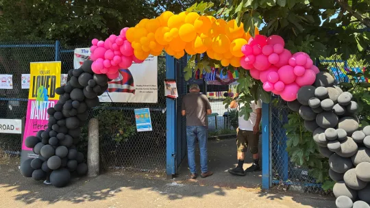Entrance to the Bridge Renewal Trust with balloons in the shape of an archway above the gate