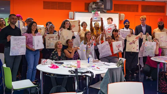 Vanessa Damali with a workshop group showing their customised tote bags