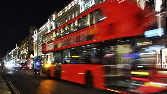 A bus on a London road at night