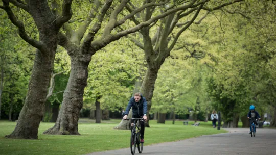 Person cycling through park