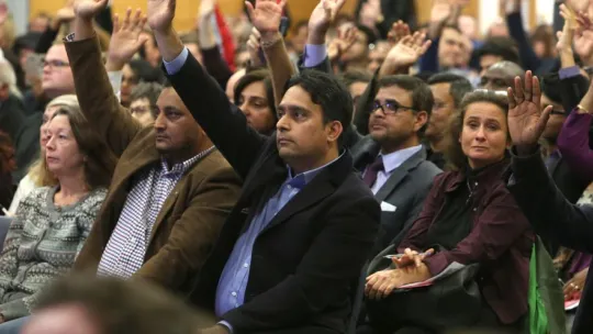A member of public raising their hand during People's Question Time.