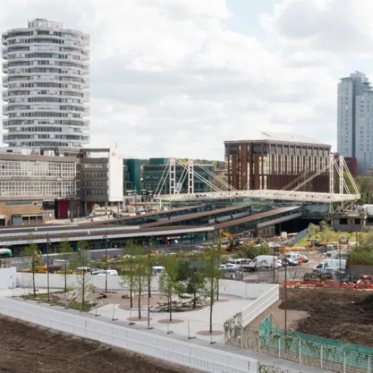 wide view of a train station city buildings behand and surrounding area