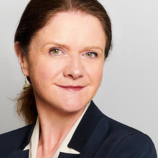 Woman in a blazer looking at the camera