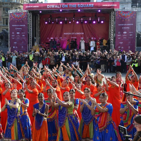 Group of dancers in front of the main stage dancing tradition South Asian dance and in traditional South Asian attire.