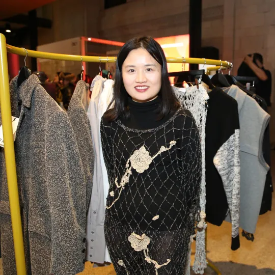 person standing in front of rail of clothes