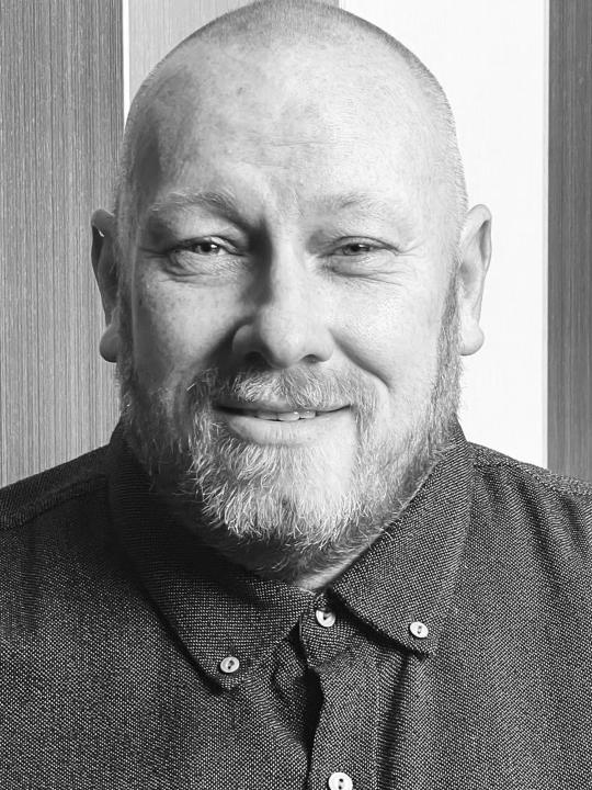 Black and white photo of man looking at the camera.