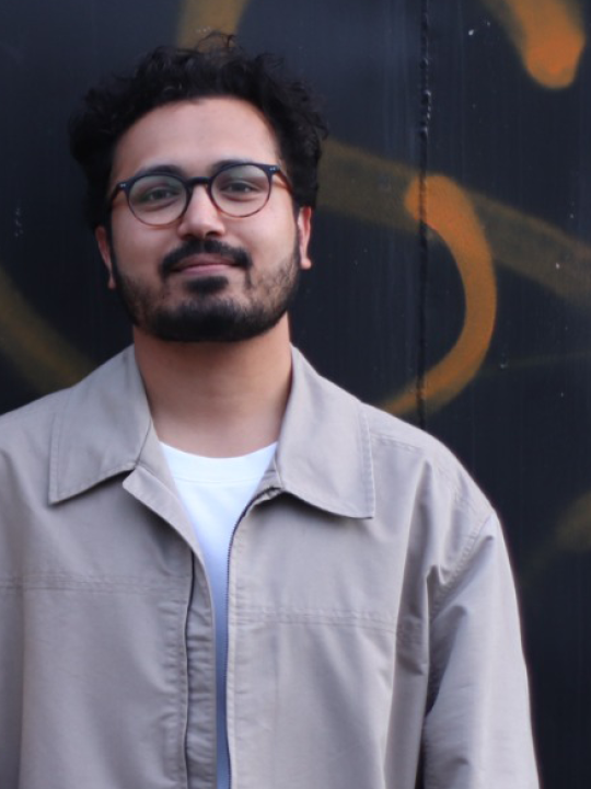 Man with glasses looking at camera.