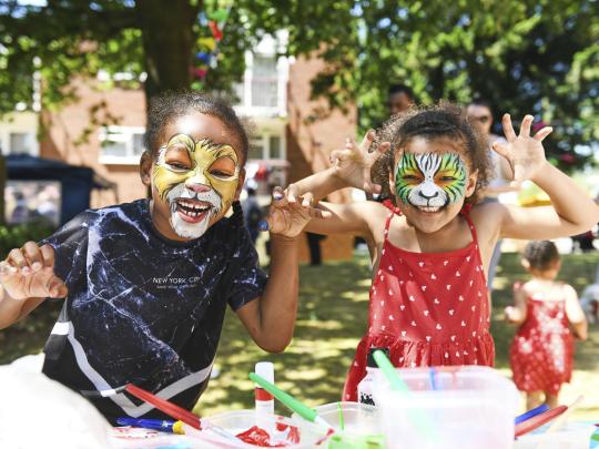 Two children wearing animal face painting