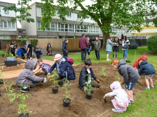 Children and adults planting as part of South Thamesmead regeneration, Peabody