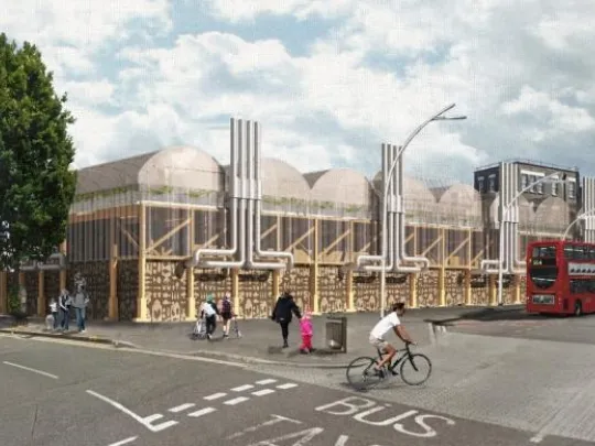 A computer generated image of The Spark project in Ilford. A view from the street with a bus passing and people walking and cycling.