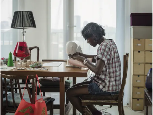 A woman sewing at her dining table