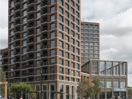 People walking along the waterfront of a riverside development