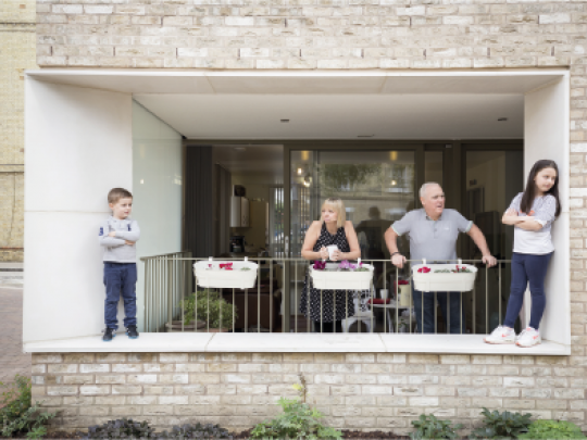 A family look out from their balcony