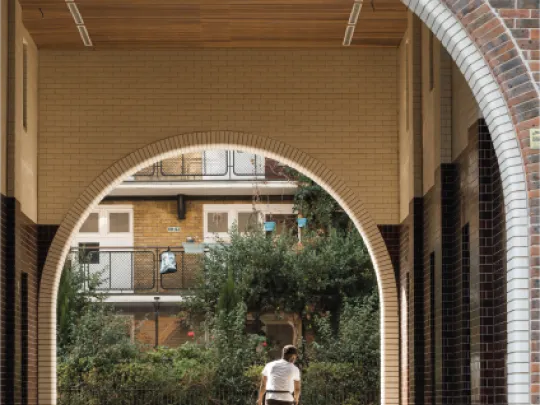 Cycling through the arched entrance to a courtyard