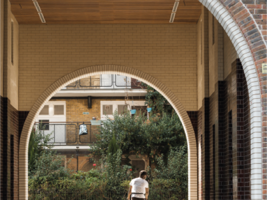 Cycling through the arched entrance to a courtyard
