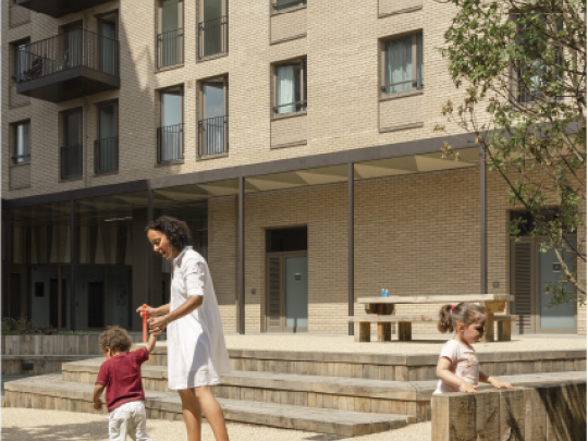 Woman and children playing outside new build flats