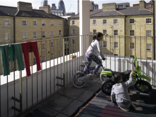 Children playing safely within a railed balcony