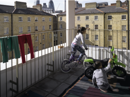 Children playing safely within a railed balcony