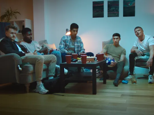 A group of friends sitting down playing computer games together