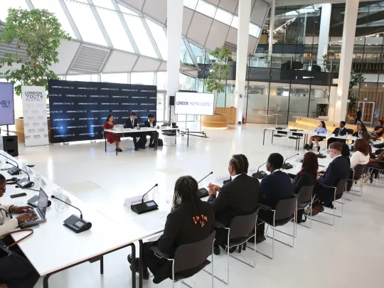 Kids in suits at desk during London Youth Assembly meeting