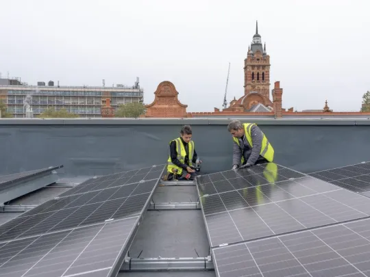 People installing solar panels on the roof of East Ham Library