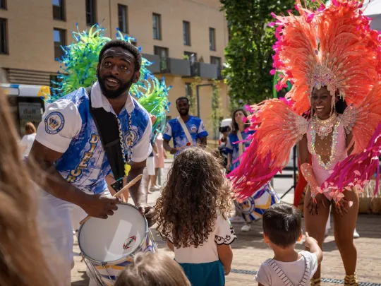 Children watching smiling carnival performers, West Hendon Carnival, London Festival of Architecture, 2024, photo by Dave Reeves