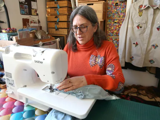 person using a sewing machine in studio