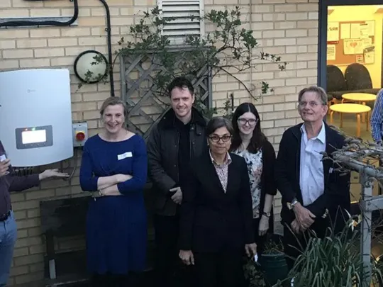 Group of people standing by a solar power generator at Caversham Group Practice