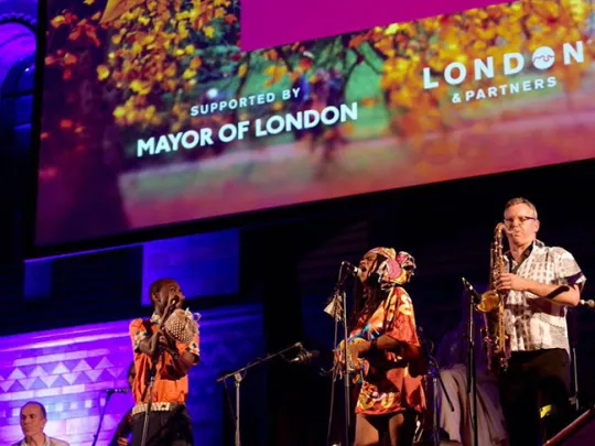 People on stage singing and playing instruments 