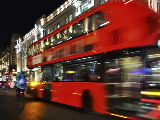 A bus on a London road at night